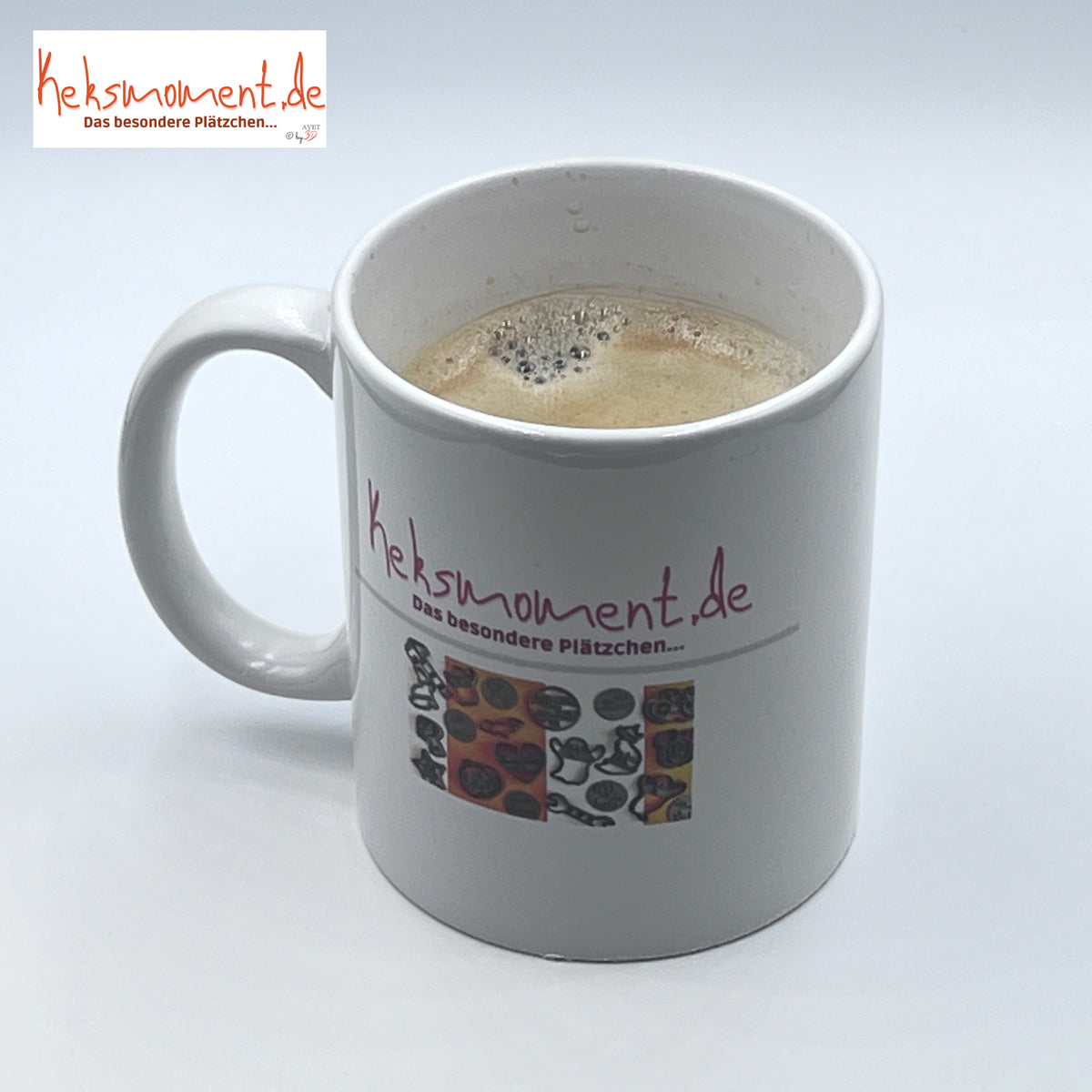 Weiße bedruckte Tasse mit Henkel und schaumigem Getränk, schräg von oben ohne Hasenmotiv.
